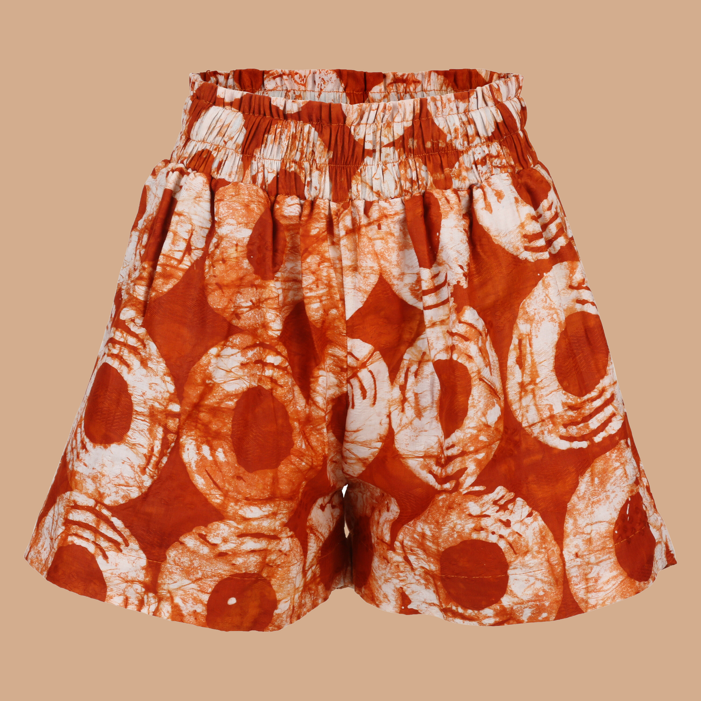 Model wearing Dreams Orange Àdìrẹ Shorts – high-waist African print shorts made from hand-dyed cotton with side pockets and elastic waistband.