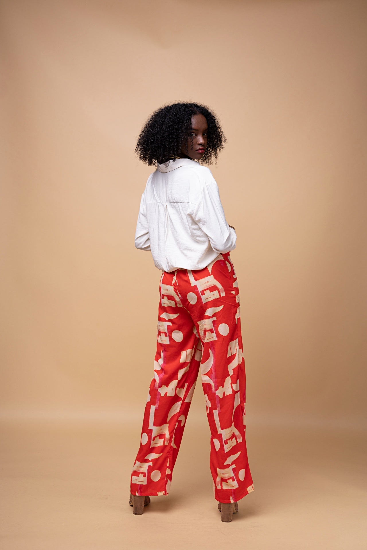 Model wearing Mpho Trousers – high-waist wide-leg cotton pants with bold African print, elastic waist, and side pockets.