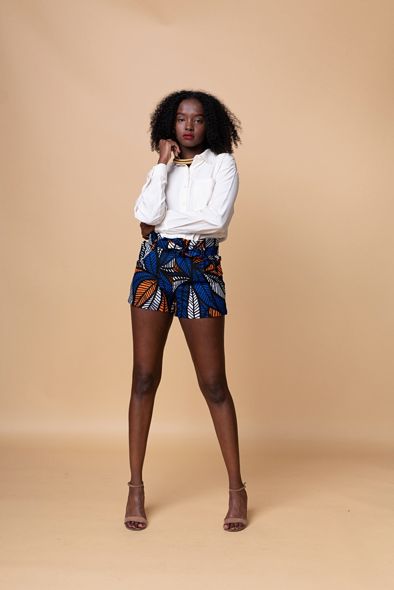 Model wearing Tikshya Shorts – high‑waist African print hand‑dyed cotton shorts with elastic waistband and side pockets.
