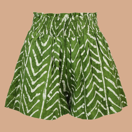 Model wearing Nro Àdìrẹ Hand Dyed Shorts – green high-waist African print cotton shorts with side pockets and elastic waistband.